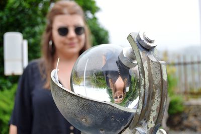 Reflection of woman standing outdoors seen in crystal ball