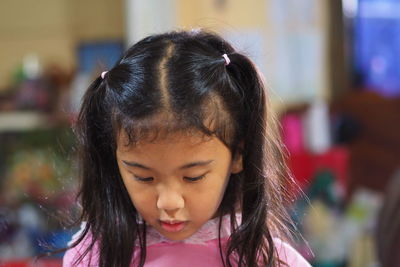 Close-up portrait of cute girl looking down