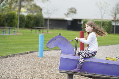 Young girl playing on rocking horse at the playground