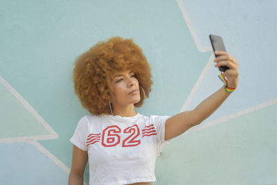 Woman with afro hair taking a selfie with her smartphone