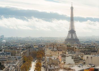 Aerial view of buildings in city against cloudy sky