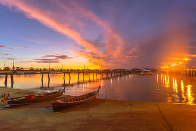 Boats moored in marina at sunset