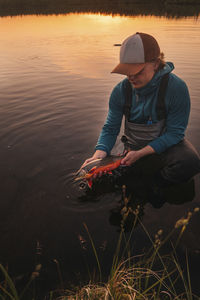 Man in river holding fish