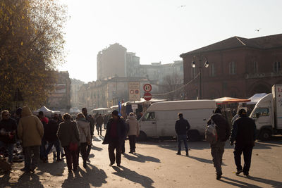 People walking on street against buildings in city