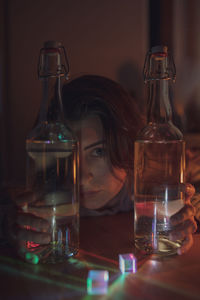 Portrait of woman with wine bottles at home