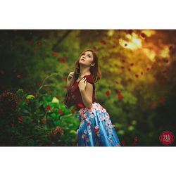 Portrait of young woman standing against plants