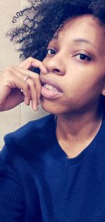 Close-up portrait of young woman using smart phone