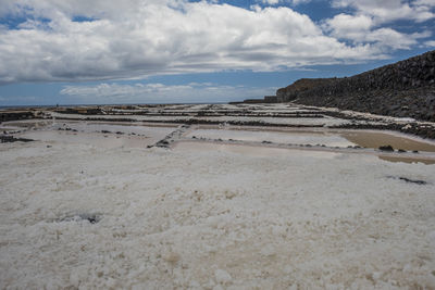 Scenic view of salt pans against sky