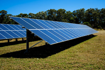 Solar panels on field against sky