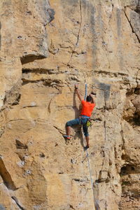 Rear view of man rock climbing