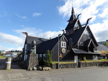 Traditional building by street against sky on sunny day