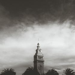 Low angle view of clock tower against cloudy sky