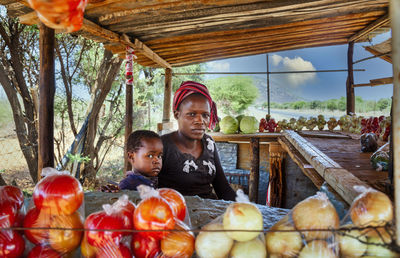 Portrait of mother and daughter at market stall