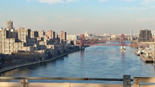 City by river against sky