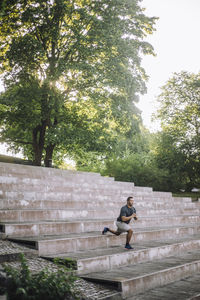 Man doing lunges on steps at park