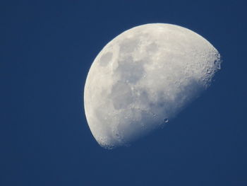 Low angle view of moon against blue sky