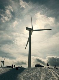 Low angle view of windmill against cloudy sky