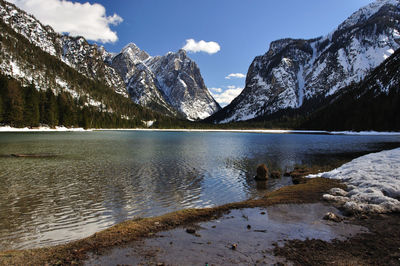 Scenic view of lake by mountains against sky