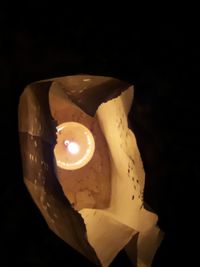 Close-up of illuminated candle against black background