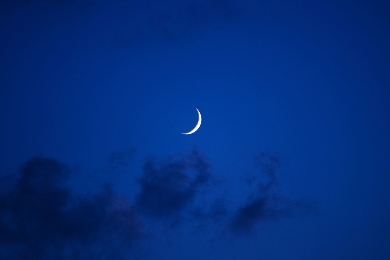 LOW ANGLE VIEW OF MOON AGAINST BLUE SKY