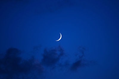 Low angle view of moon in blue sky