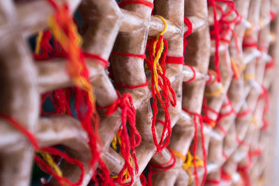 Close-up of thread tied on patterned wall