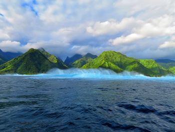 Scenic view of sea and mountains against sky