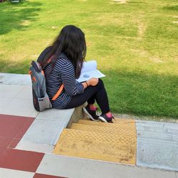 Full length of woman sitting on bench
