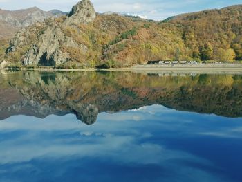 Scenic view of lake by mountains against sky