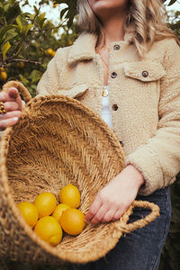 Midsection of woman holding ice cream cone in basket