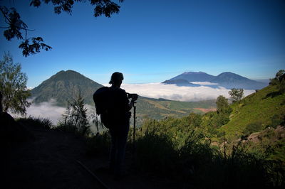 Rear view of woman taking photo on the way to ijen volcano, indonesia