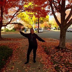 Full length of senior woman standing in park during autumn