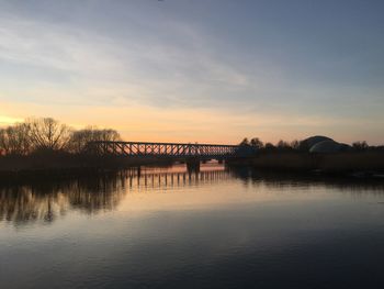 Bridge over river against sky during sunset