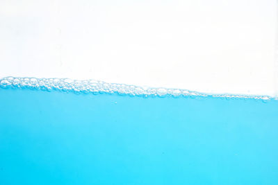 Close-up of bubbles over sea against white background