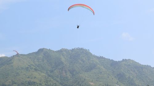 Low angle view of person paragliding against clear sky