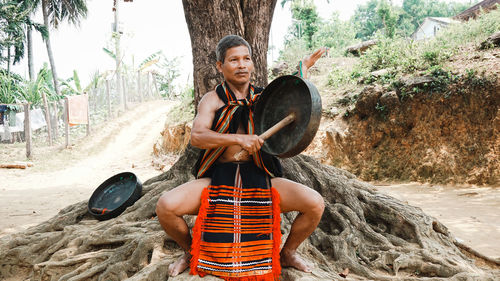 Portrait of young man sitting on rock