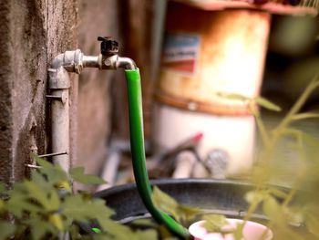 Close-up of old faucet against wall