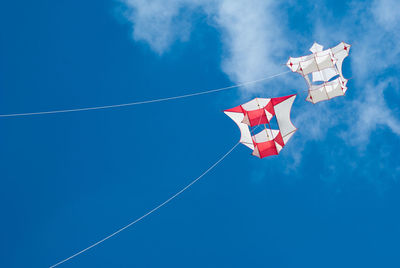 Low angle view of flags against blue sky