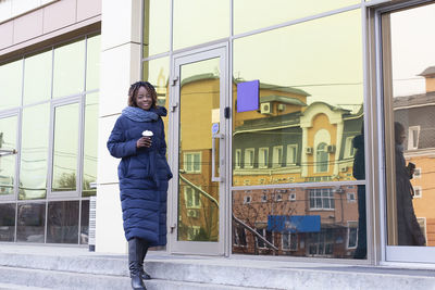 Full length of man standing by building in city