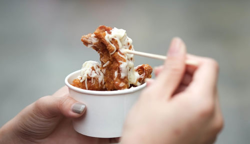 Close-up of woman hand holding fried chicken in cup