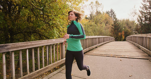 Full length of woman running on footbridge