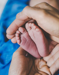 Hands of woman holding baby feet