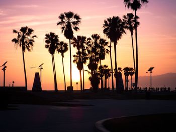 Silhouette palm trees against sky during sunset