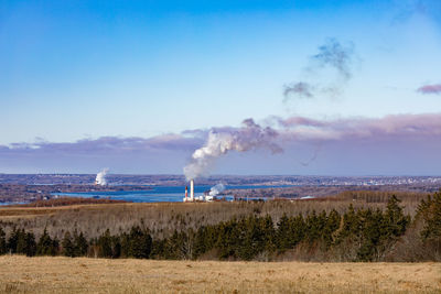 Smoke emitting from chimney against sky