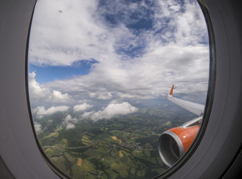 Cropped image of airplane wing over landscape