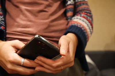 Female hand holding black phone. close up of a woman using mobile smart phone. millennial 