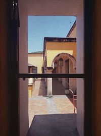 Building seen through open window of house