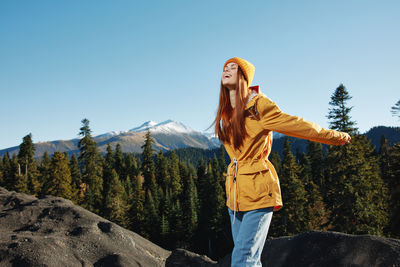 Side view of woman standing against mountain