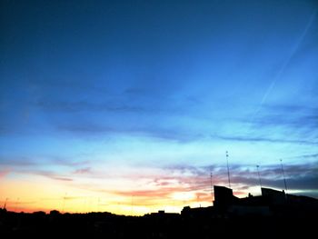 Silhouette of cityscape against dramatic sky