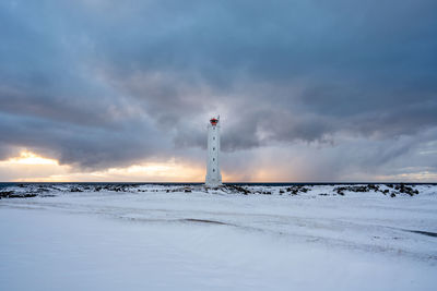 Scenic view of snow covered field against sky during sunset